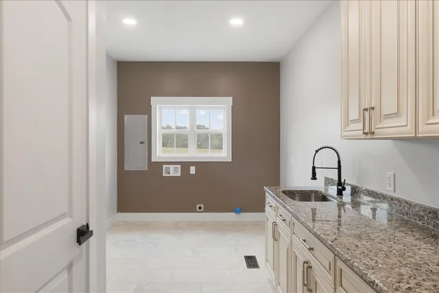 a kitchen with granite countertop white cabinets and sink