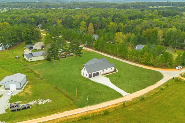 a view of a green yard with large trees