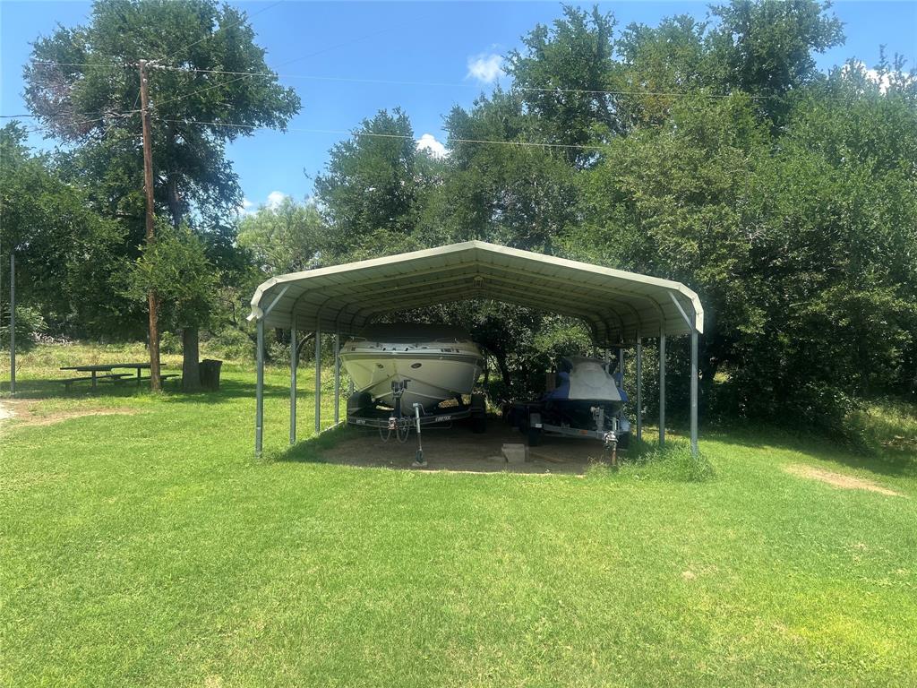 4705 Fox Hollow Road Graham, TX 76450 - Photo 7 of 28 View of car parking featuring a carport and view of wooded area