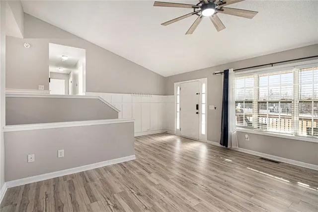 a kitchen with stainless steel appliances wooden floor and a refrigerator