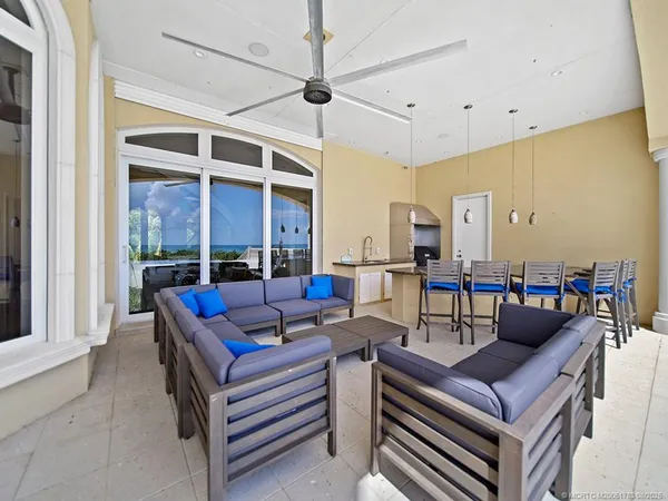a living room with furniture and floor to ceiling windows