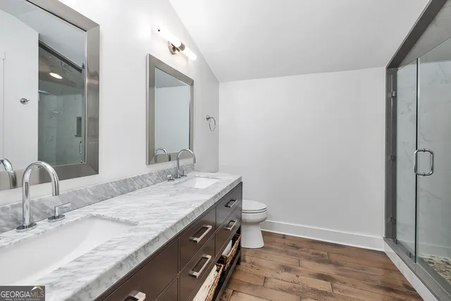 a bathroom with a granite countertop sink a toilet and shower