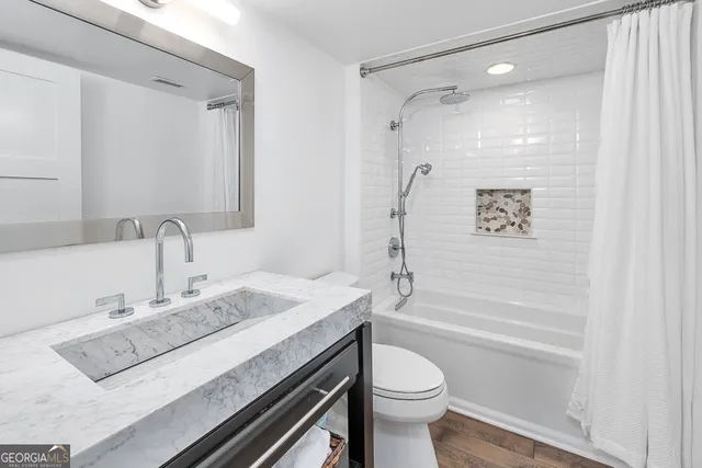 a bathroom with a sink a toilet and shower