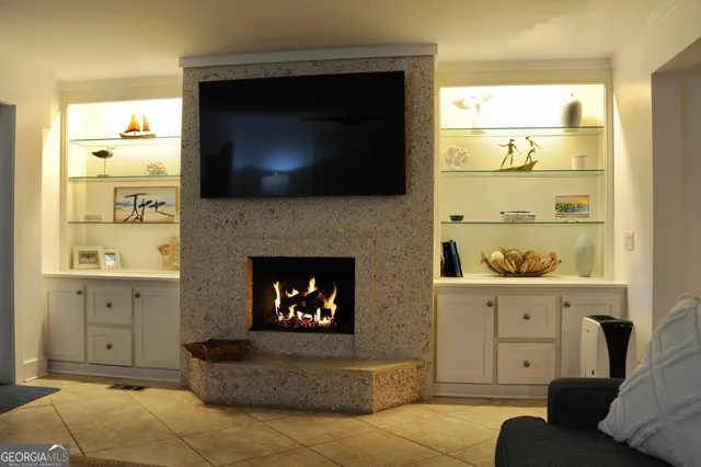 a living room with furniture a flat screen tv and a fireplace