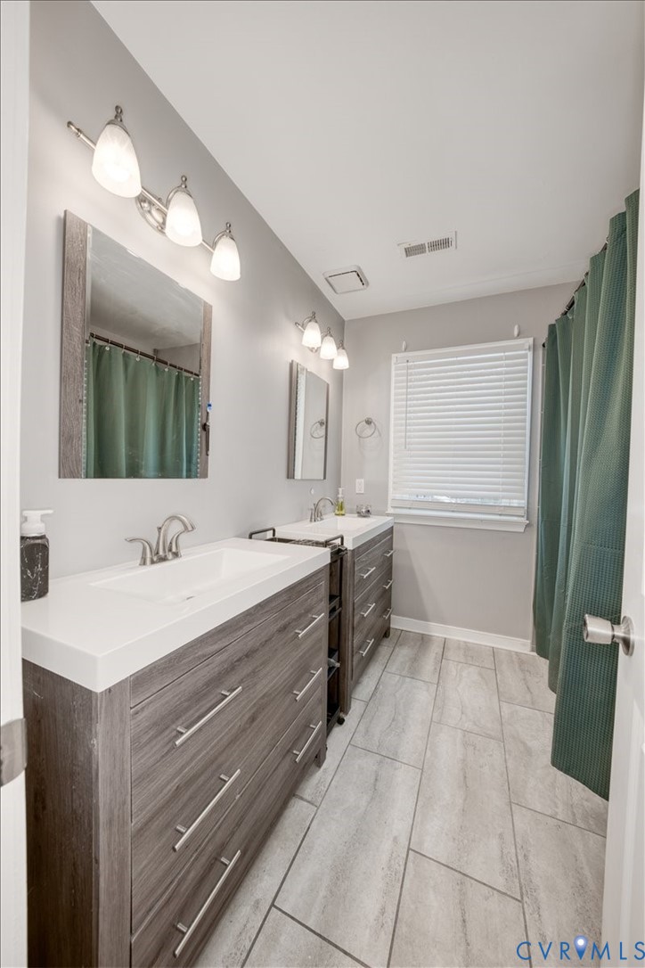 11201 Puckett Place Midlothian, VA 23112 - Photo 15 of 23 a large bathroom with a double vanity sink a large mirror and a bathtub