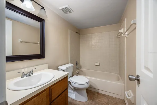 a bathroom with a toilet a sink a mirror and a bathtub