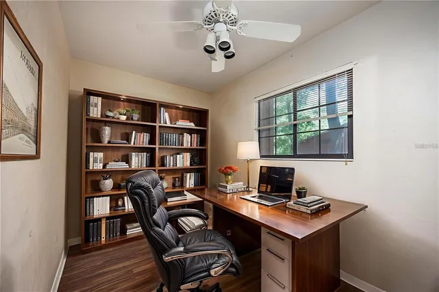 a view of a workspace with furniture and a bookshelf
