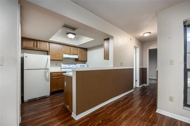 a kitchen with refrigerator cabinets and wooden floor