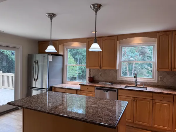 a kitchen with stainless steel appliances granite countertop a sink a window and a counter top space