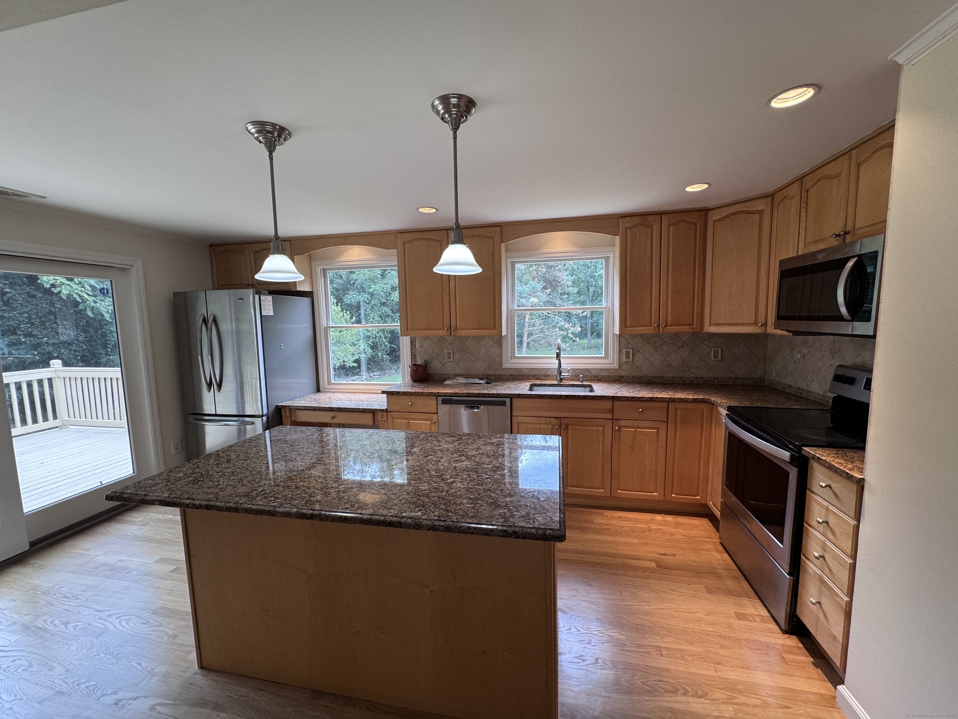 18 Hales Road Westport, CT 06880 - Photo 4 of 26 a kitchen with granite countertop a stove a sink a center island and windows