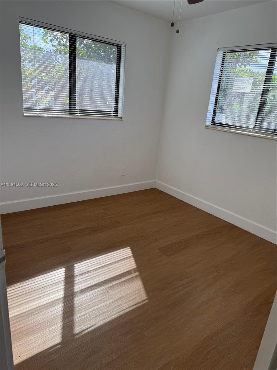 180 Northeast 71st Street, Unit 5 Miami, FL 33138 - Photo 12 of 12 a view of a small space with wooden floor and a window