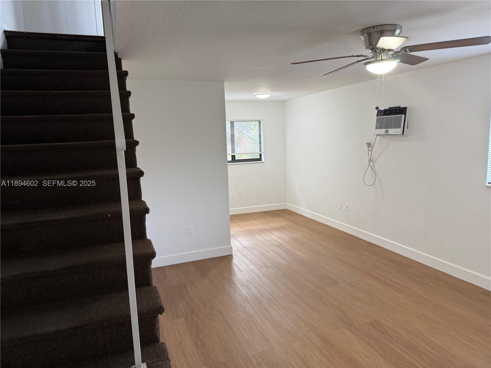 180 Northeast 71st Street, Unit 5 Miami, FL 33138 - Photo 2 of 12 wooden floor in an empty room with a window