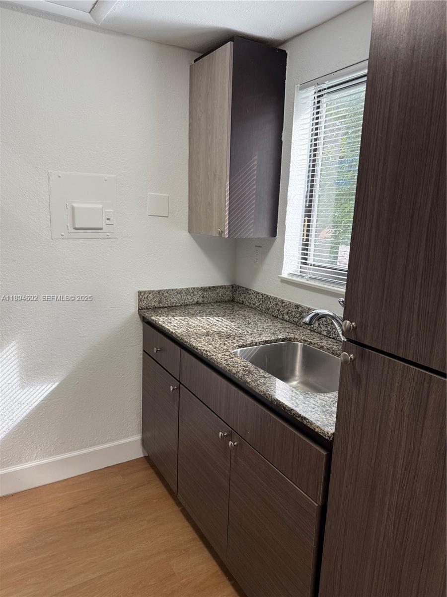 180 Northeast 71st Street, Unit 5 Miami, FL 33138 - Photo 5 of 12 a kitchen with a sink stove and cabinets