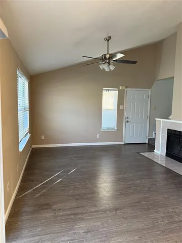 an empty room with windows and fireplace