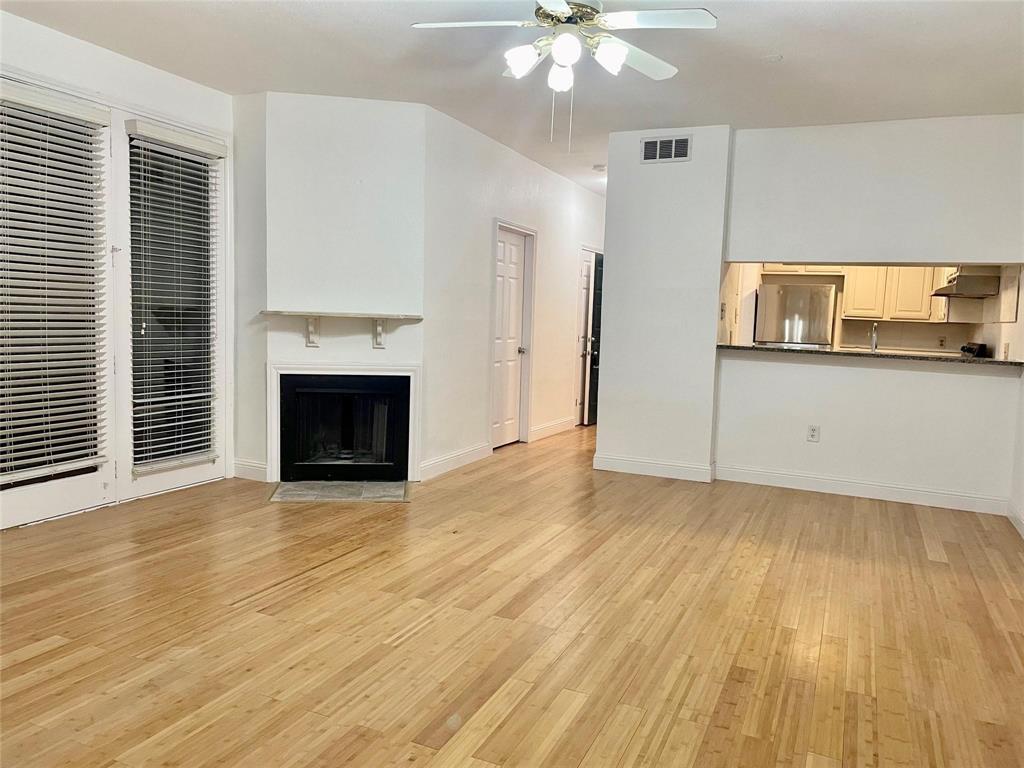 8545 Midpark Road, Unit 11 Dallas, TX 75240 - Photo 2 of 18 an empty room with wooden floor fireplace and windows
