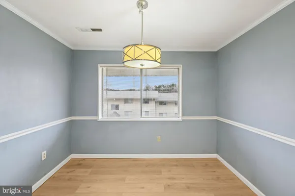 a view of an empty room with a window and chandelier fan