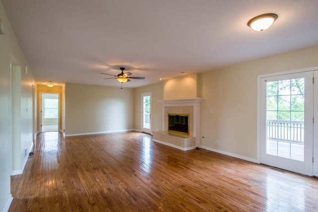 12N330 Switzer Road Elgin, IL 60124 - Photo 10 of 25 an empty room with wooden floor fireplace and windows