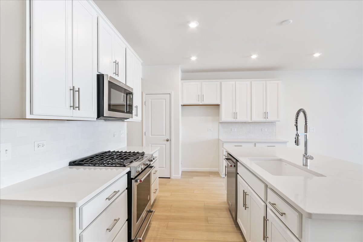644 Switchgrass Way, Unit 59002 Bolingbrook, IL 60490 - Photo 6 of 26 a kitchen with a sink stove top oven and cabinets