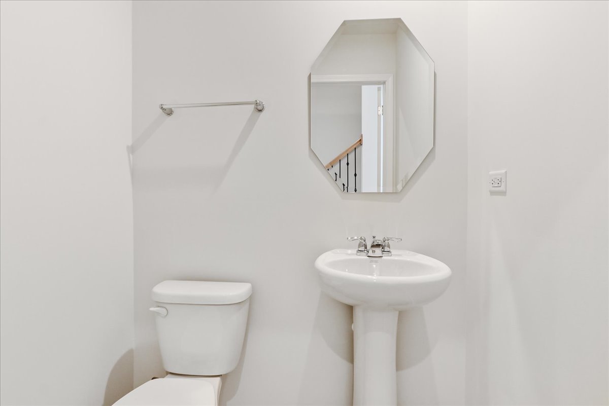 644 Switchgrass Way, Unit 59002 Bolingbrook, IL 60490 - Photo 12 of 26 a bathroom with a toilet sink and mirror