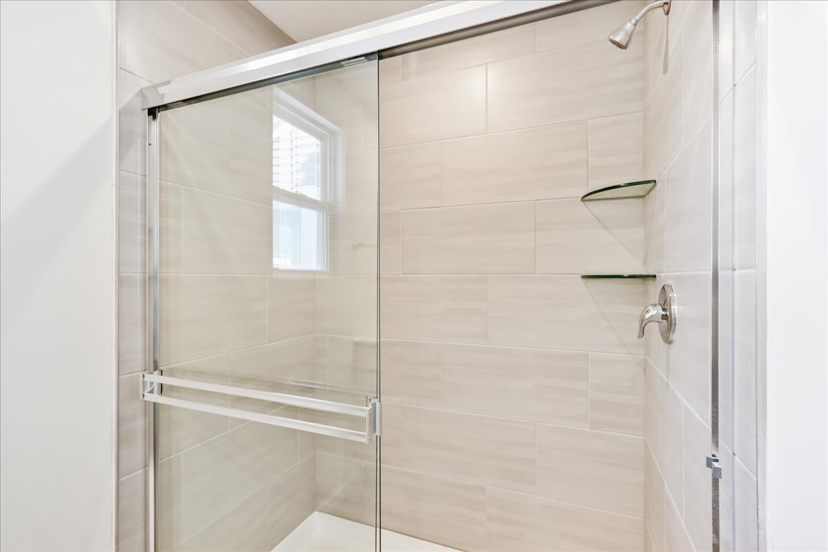 644 Switchgrass Way, Unit 59002 Bolingbrook, IL 60490 - Photo 19 of 26 a bathroom with a glass shower door