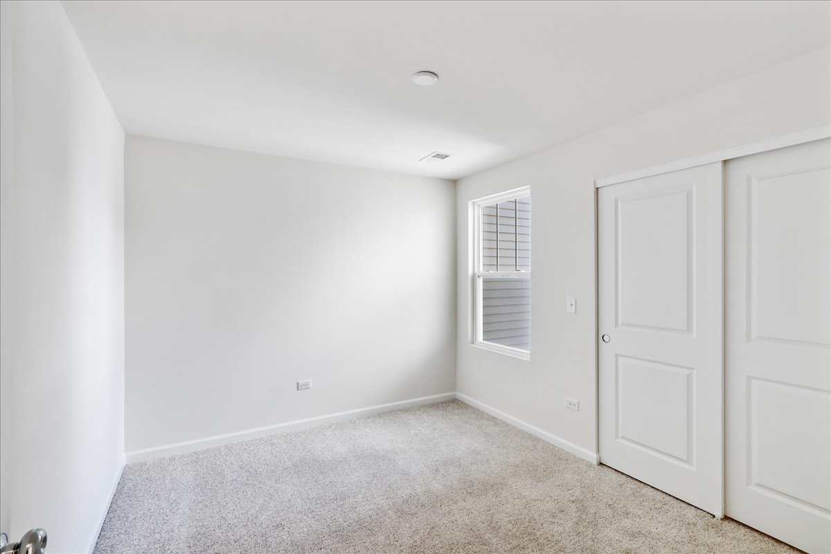 644 Switchgrass Way, Unit 59002 Bolingbrook, IL 60490 - Photo 21 of 26 a view of an empty room with a window