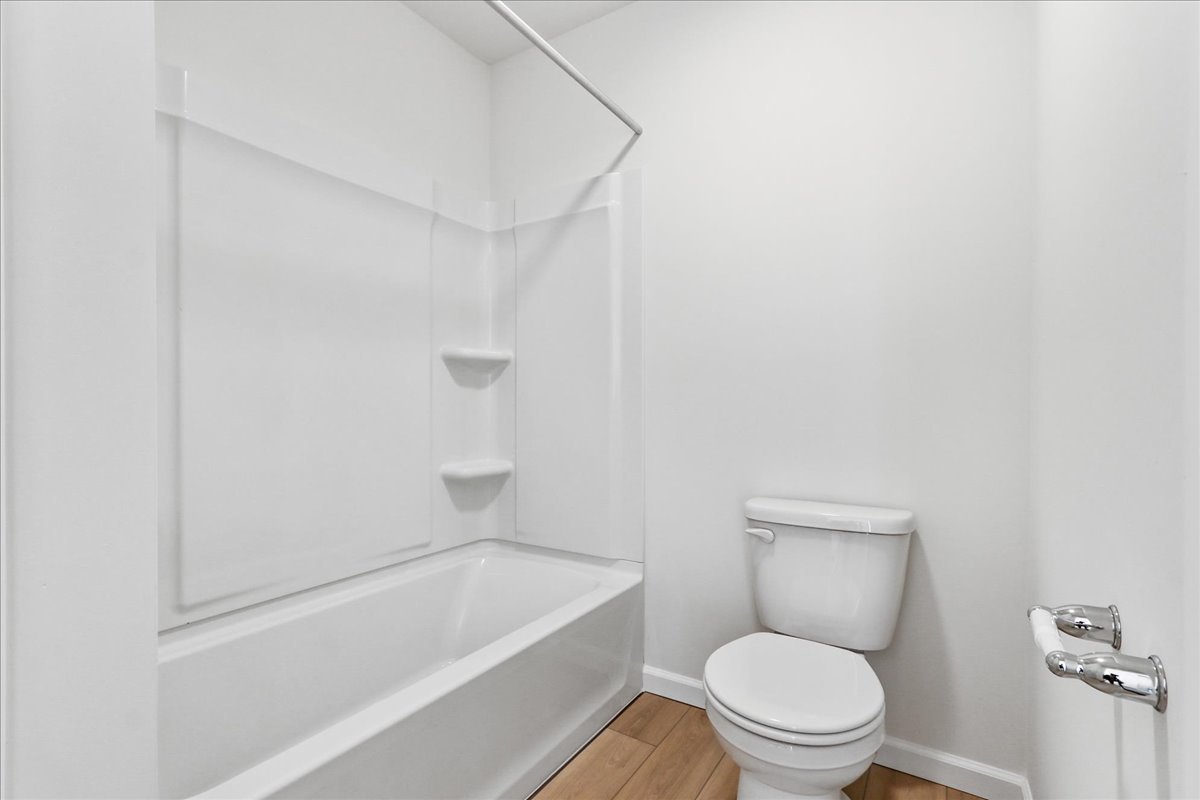 644 Switchgrass Way, Unit 59002 Bolingbrook, IL 60490 - Photo 23 of 26 a white toilet sitting next to a bath tub