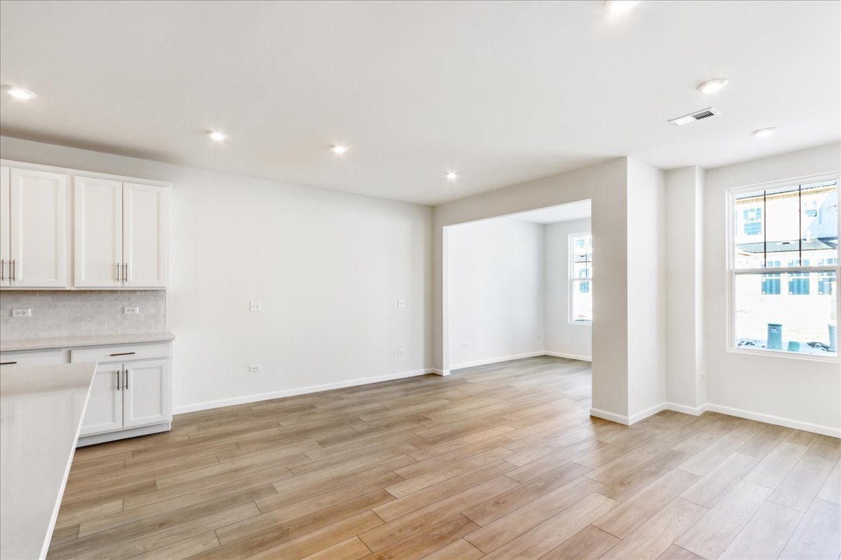 644 Switchgrass Way, Unit 59002 Bolingbrook, IL 60490 - Photo 2 of 26 a view of an empty room with wooden floor and a window