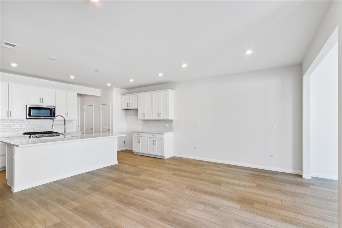 644 Switchgrass Way, Unit 59002 Bolingbrook, IL 60490 - Photo 3 of 26 a kitchen with stainless steel appliances granite countertop a stove top oven a sink and a refrigerator