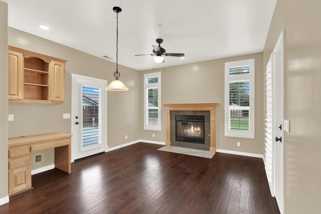 16308 Swartz Canyon Road Ramona, CA 92065 - Photo 13 of 29 a view of a kitchen with a fireplace a ceiling fan and wooden floor