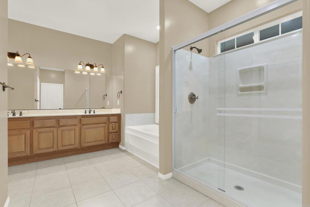 16308 Swartz Canyon Road Ramona, CA 92065 - Photo 16 of 29 a bathroom with a granite countertop sink a mirror a bathtub and shower
