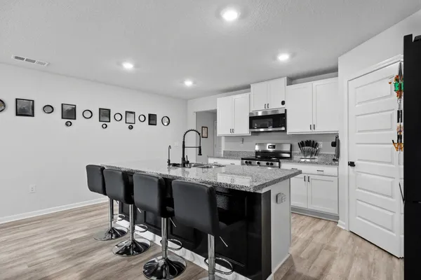 a kitchen with granite countertop a sink cabinets and stainless steel appliances