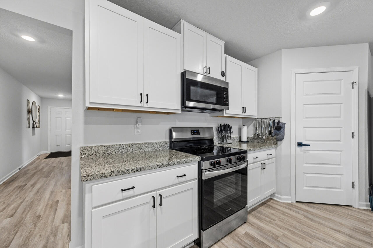 3411 Phoenix Court Crestview, FL 32539 - Photo 17 of 47 a kitchen with granite countertop white cabinets appliances and wooden floor
