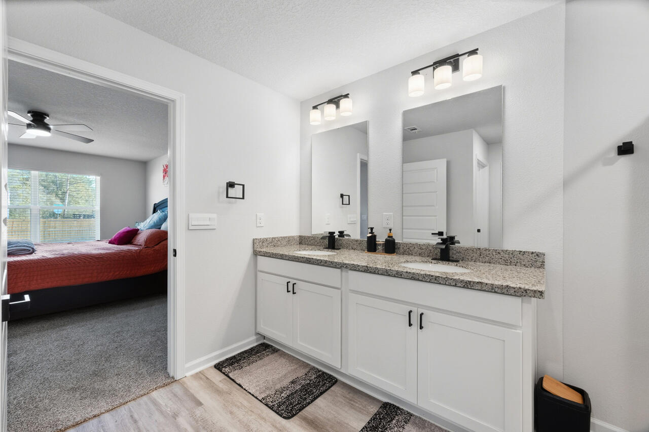 3411 Phoenix Court Crestview, FL 32539 - Photo 23 of 47 a en suite bathroom with a granite countertop sink and a mirror