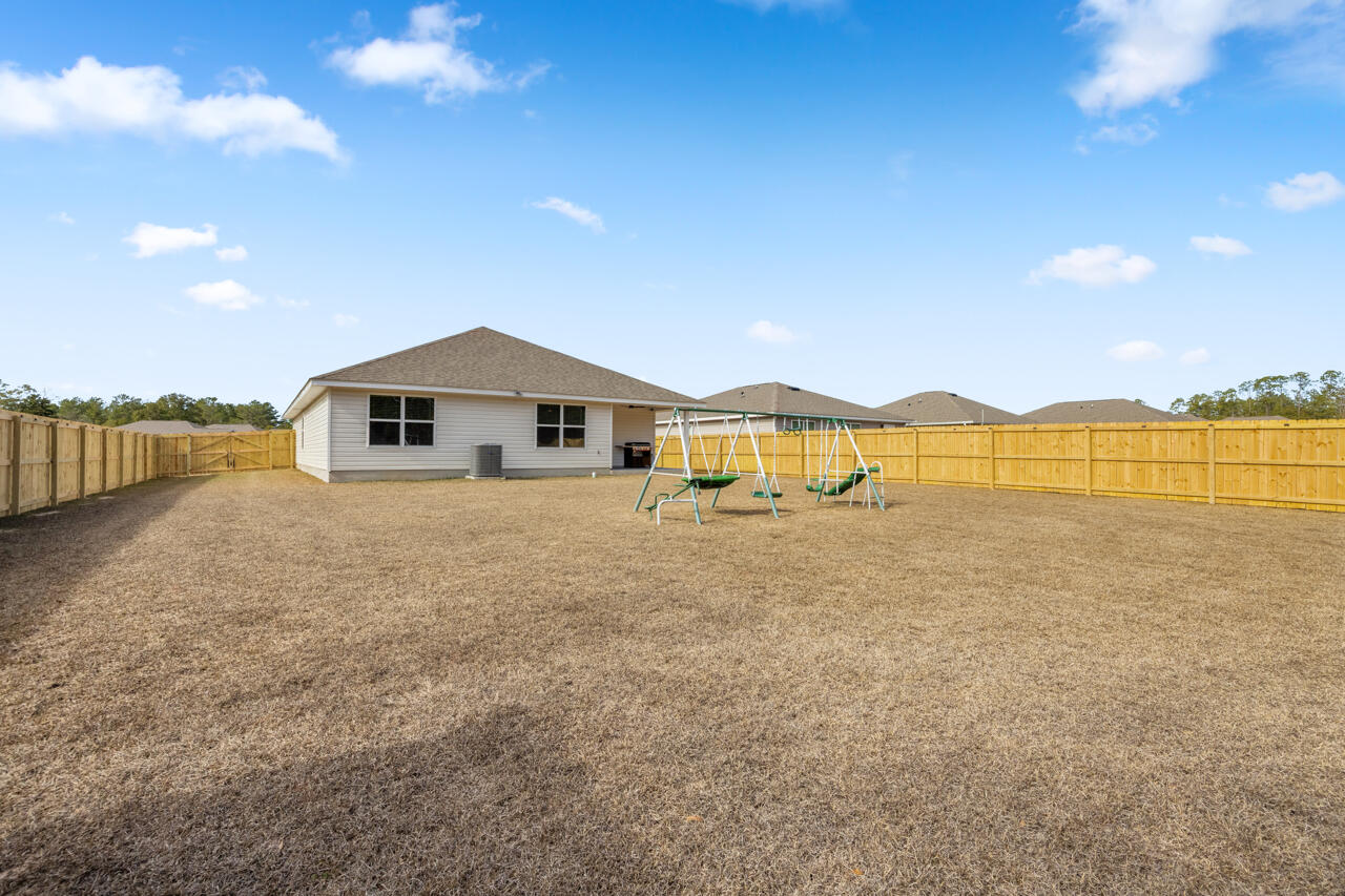 3411 Phoenix Court Crestview, FL 32539 - Photo 38 of 47 a large white house with a yard and lake view