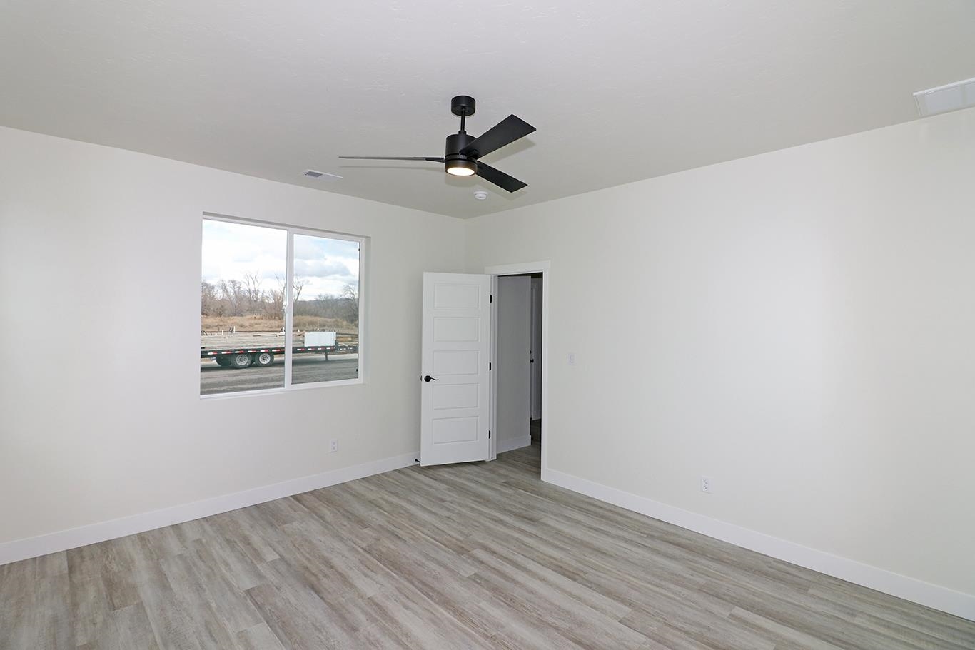 1654 Tungsten Way Fruita, CO 81521 - Photo 11 of 22 an empty room with wooden floor and windows