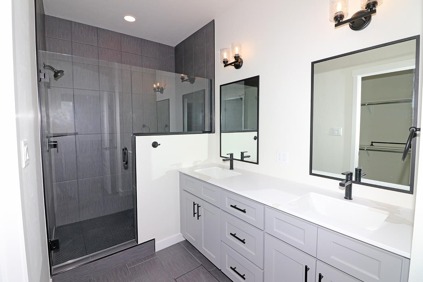 1654 Tungsten Way Fruita, CO 81521 - Photo 12 of 22 a bathroom with a double vanity sink a mirror and shower