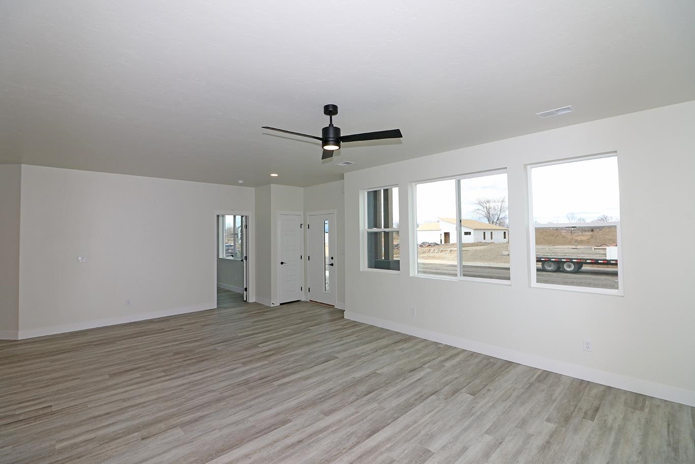 1654 Tungsten Way Fruita, CO 81521 - Photo 7 of 22 an empty room with wooden floor and windows