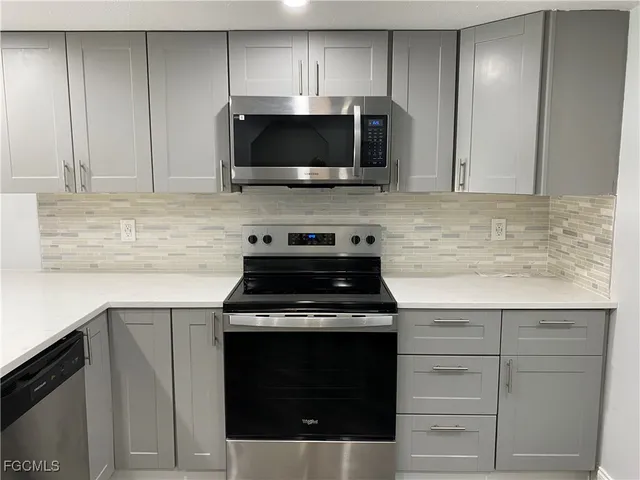 a kitchen with granite countertop cabinets stainless steel appliances and wooden cabinets