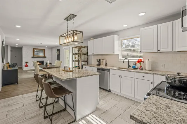 a kitchen with sink cabinets and dining table chairs