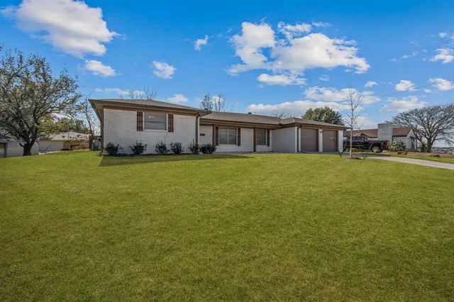 a view of a house with a yard and sitting area