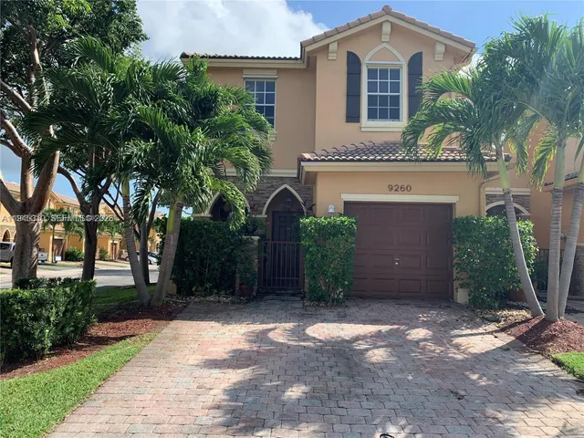 a front view of a house with a yard and a garage