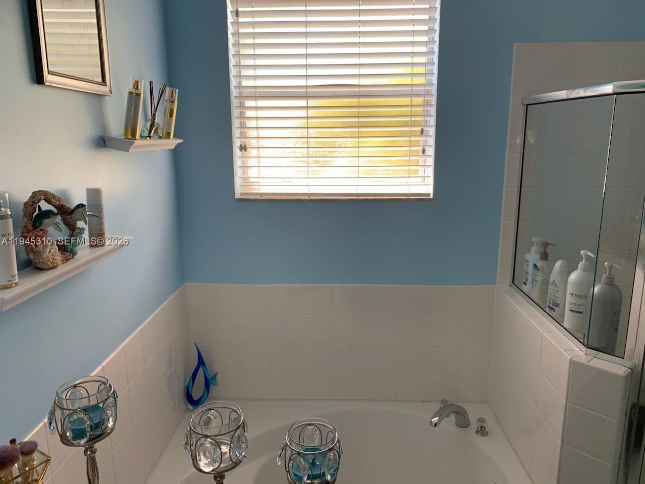 9260 Southwest 220th Street Cutler Bay, FL 33190 - Photo 14 of 20 a bathroom with a tub sink and a window