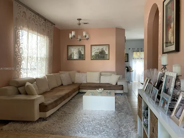 a living room with furniture flat screen tv and window