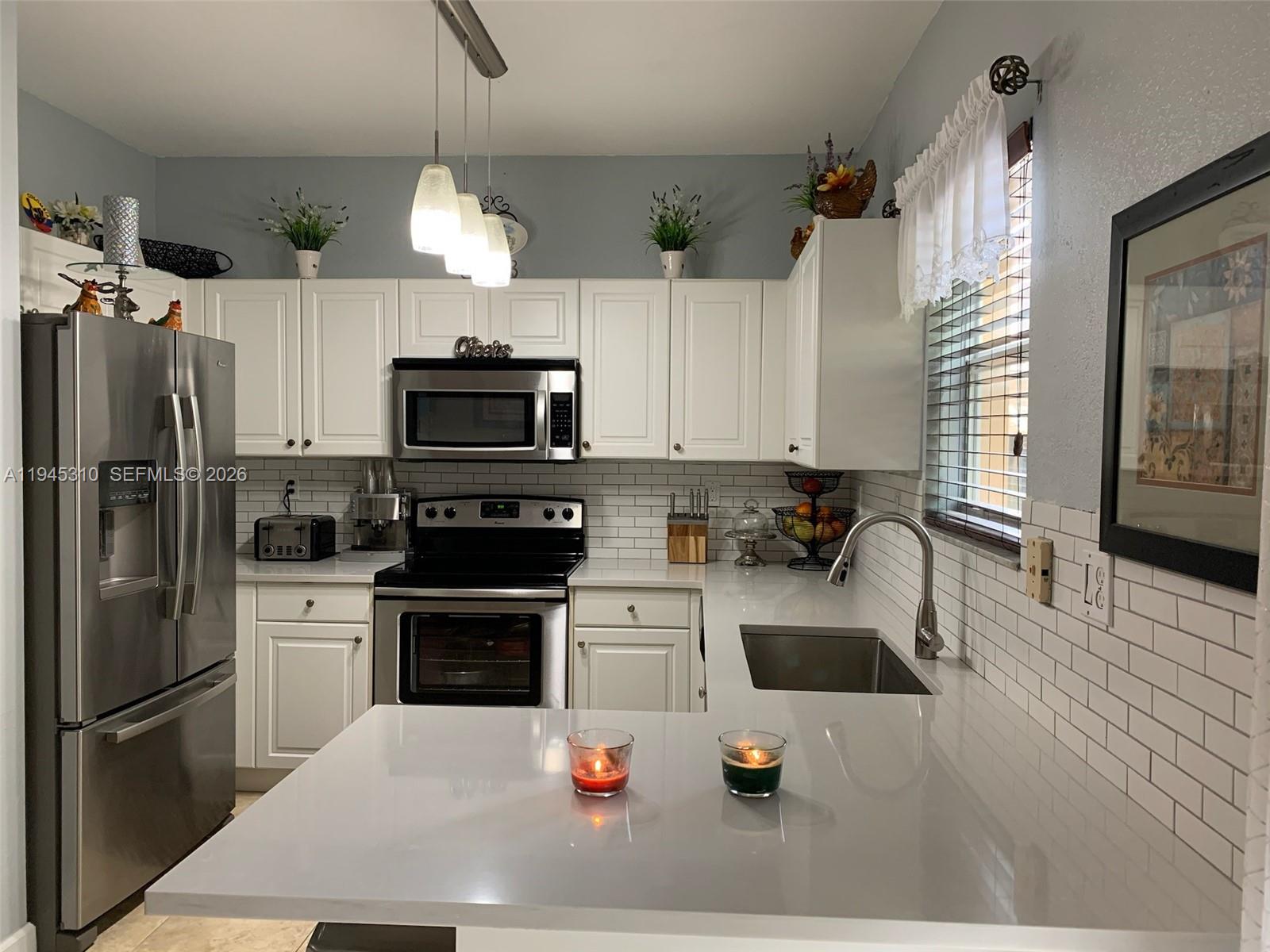 9260 Southwest 220th Street Cutler Bay, FL 33190 - Photo 5 of 20 a kitchen with a sink a microwave a stove and refrigerator