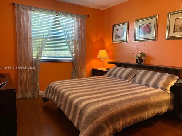 a bedroom with bed and wooden floor