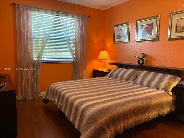 a bedroom with bed and wooden floor