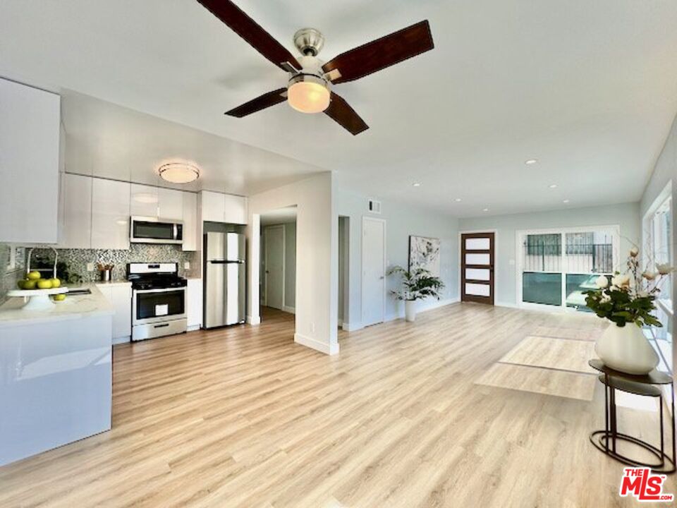 2012 South Bedford Street, Unit 1 Los Angeles, CA 90034 - Photo 1 of 17 a large kitchen with stainless steel appliances kitchen island granite countertop a stove and a wooden floors