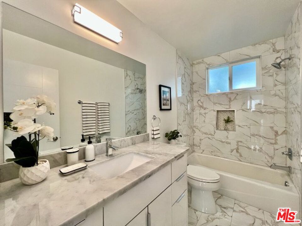 2012 South Bedford Street, Unit 1 Los Angeles, CA 90034 - Photo 5 of 17 a bathroom with a granite countertop sink mirror toilet and bathtub