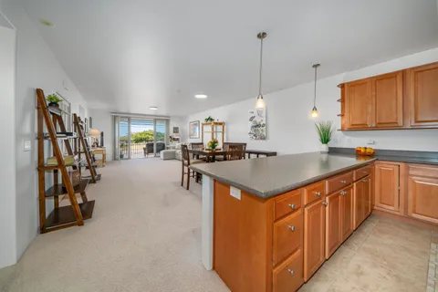 a kitchen with stainless steel appliances kitchen island granite countertop a sink a counter top space cabinets and a window