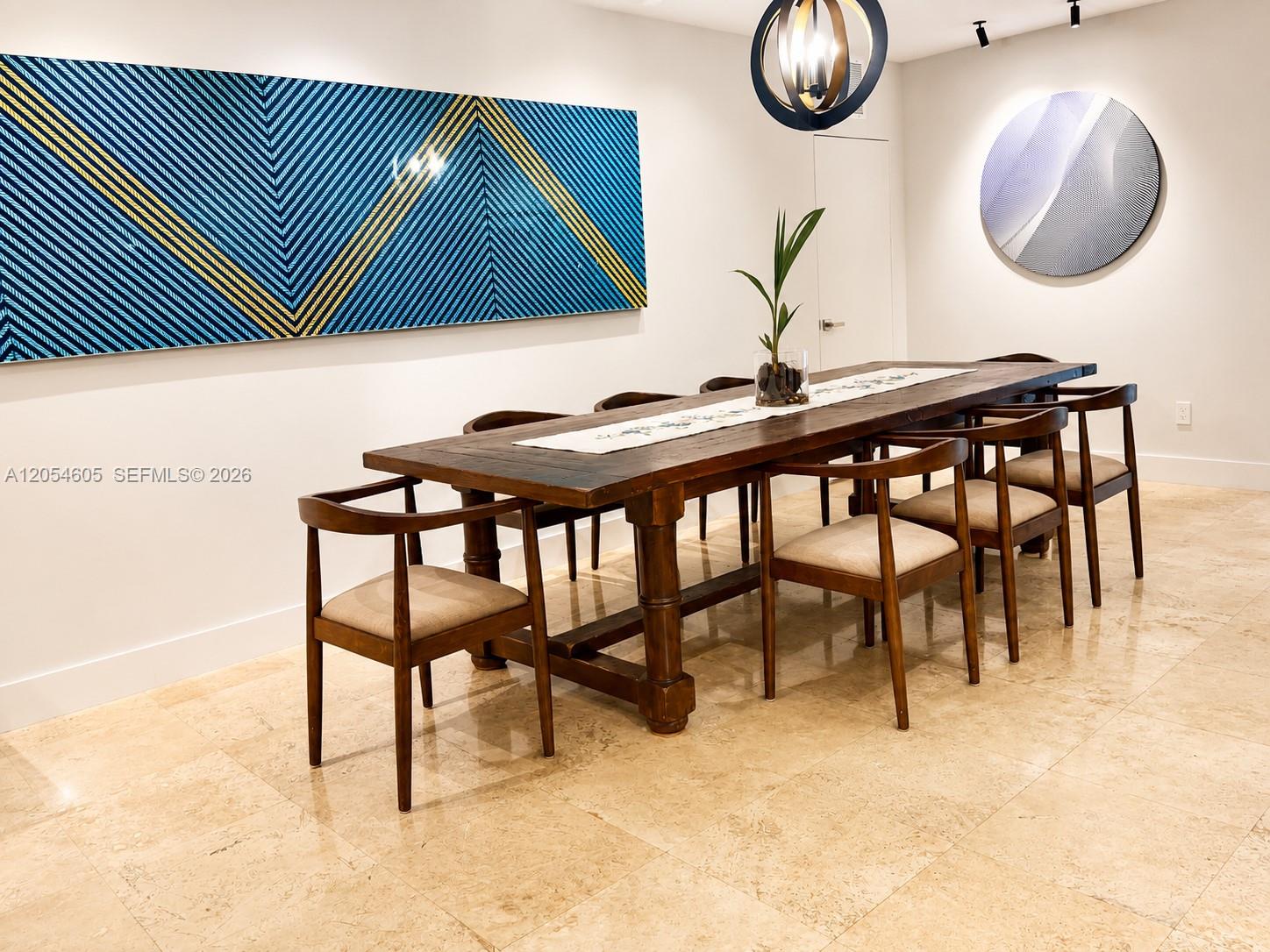 3538 Southwest 1st Avenue, Unit 1 Miami, FL 33145 - Photo 6 of 20 Sophisticated formal dining room featuring a custom art gallery wall with dedicated accent lighting that beautifully showcases artwork and creates an elegant ambiance. Marble floors, recessed lighting, expansive open spaces, and abundant natural light provide a bright, inviting atmosphere. The custom solid wood dining table seats up to 10 guests, making this the perfect setting for family dinners, holiday celebrations, and effortless entertaining.